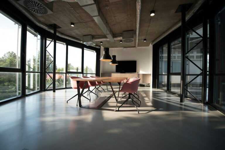 A professional meeting room with a large table and chairs, representing a space where people can gather, share knowledge, and build community.