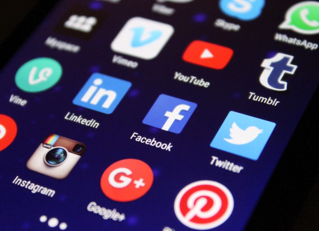 A phone showing social media apps on screen, representing digital conversations, comments, and marketing inside communities.