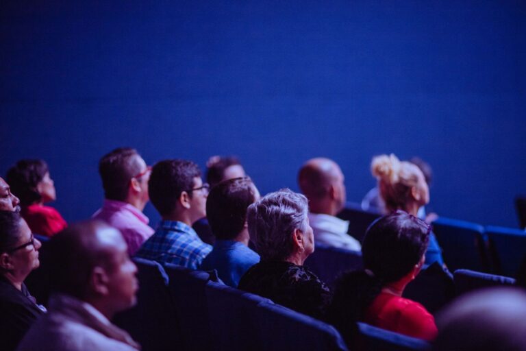A conference hall audience seen from behind, representing a physical interaction that can become a digital journey.