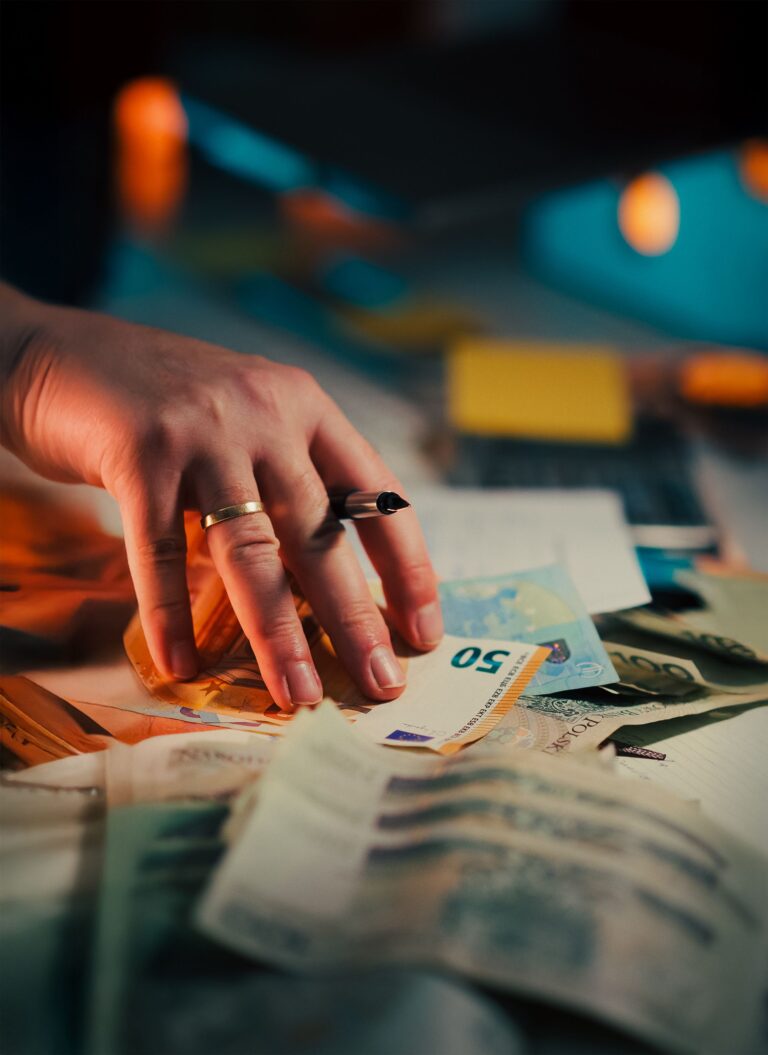 Euro banknotes over financial documents and a pen as a metaphor for a transaction waiting for approval and delivery