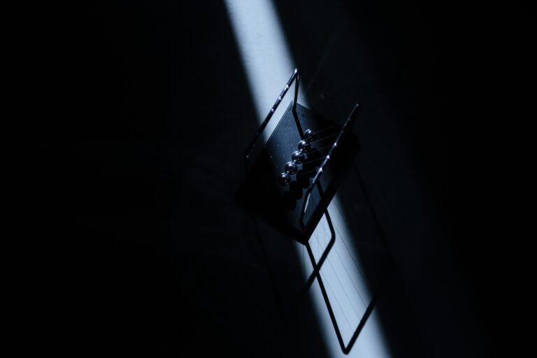 A Newton's cradle in a dark room as a metaphor for hidden forces that move conversions in digital marketing